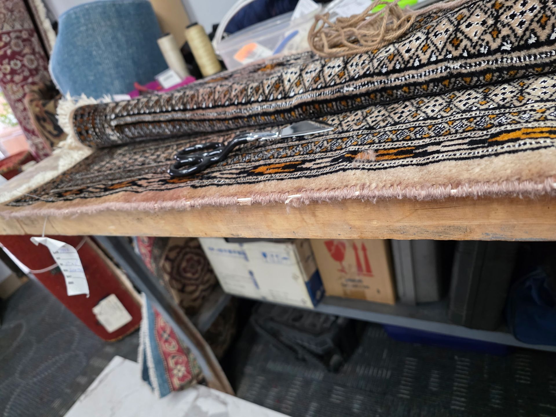 Folded patterned textiles stacked on a table in a shop or market stall.