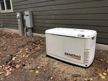 Generac home standby generator beside a house on a gravel yard