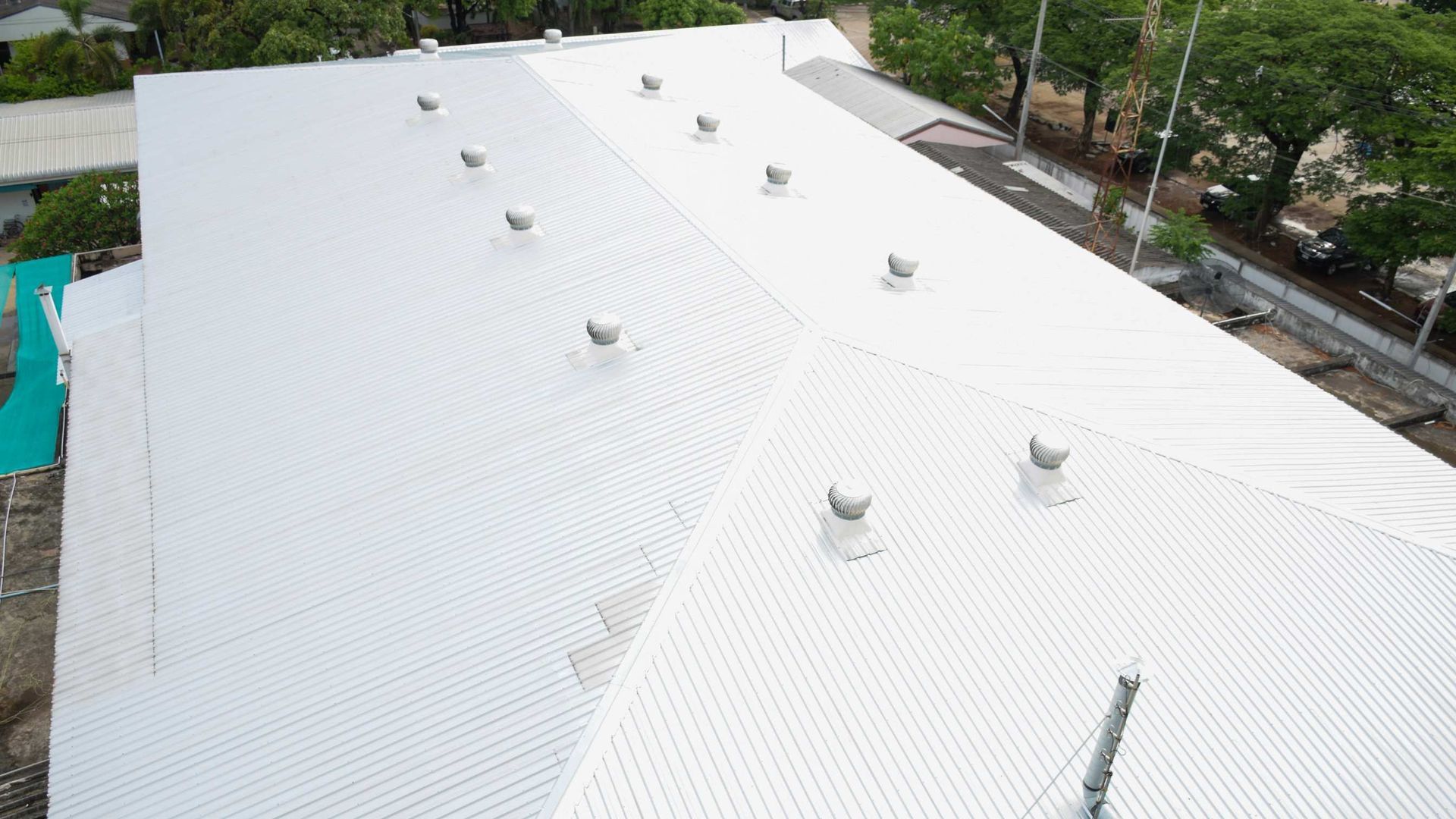 White metal rooftop with multiple vents, viewed from above.