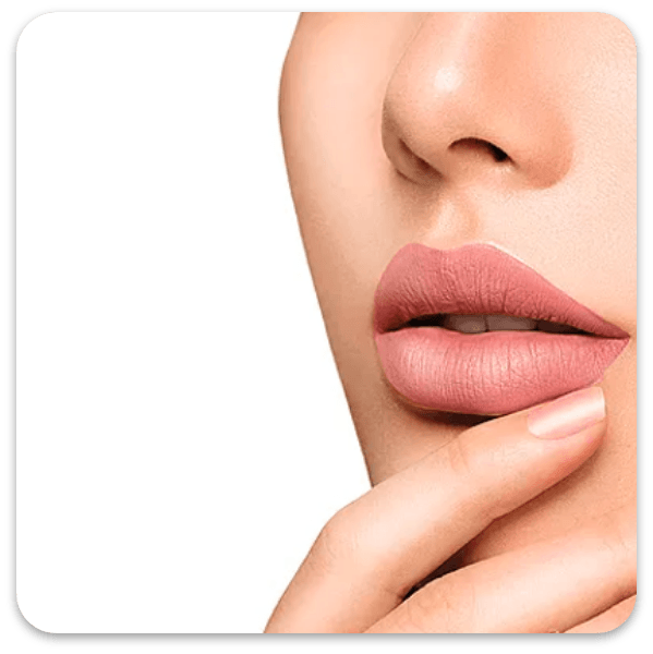 Eine Nahaufnahme von Lippen mit mattem, gedecktem rosa Lippenstift, während ein Finger sanft in der Nähe des Kinns ruht.