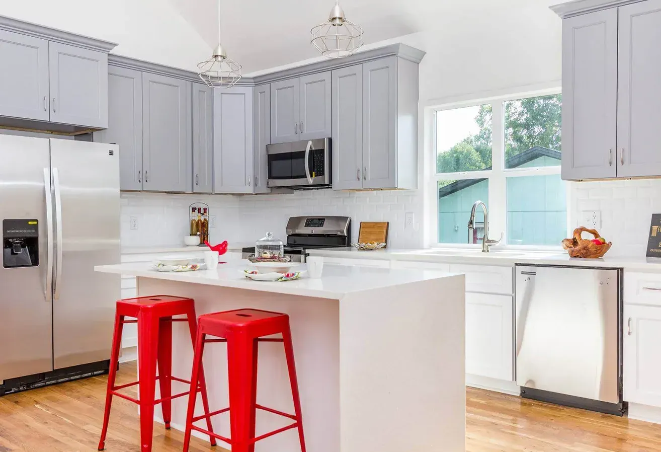 Partially renovated kitchen with dark lower cabinets, wood countertops, beige walls, and a window above the sink.