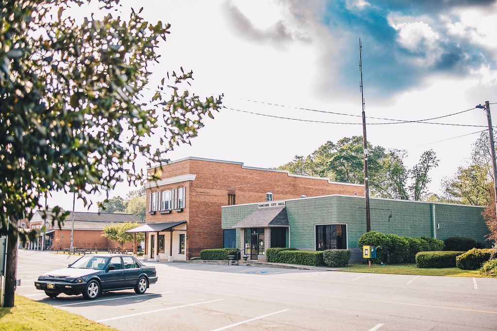 A car is parked in front of a large building.