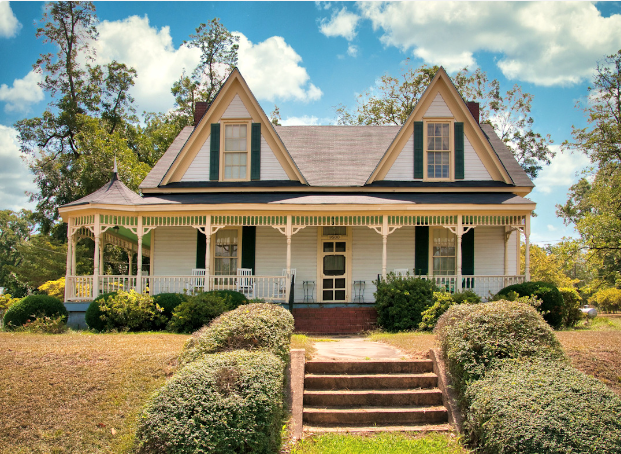 A white house with a porch and stairs leading up to it