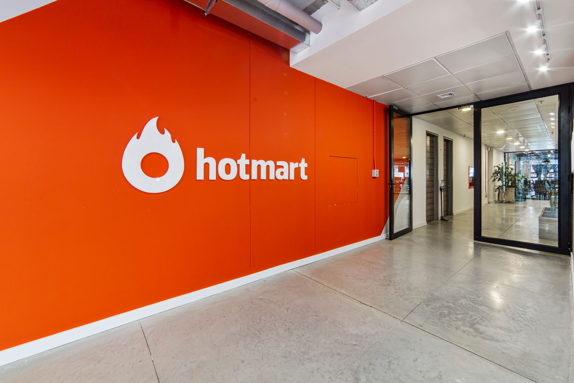 Uma grande parede laranja com o logotipo da hotmart nela.