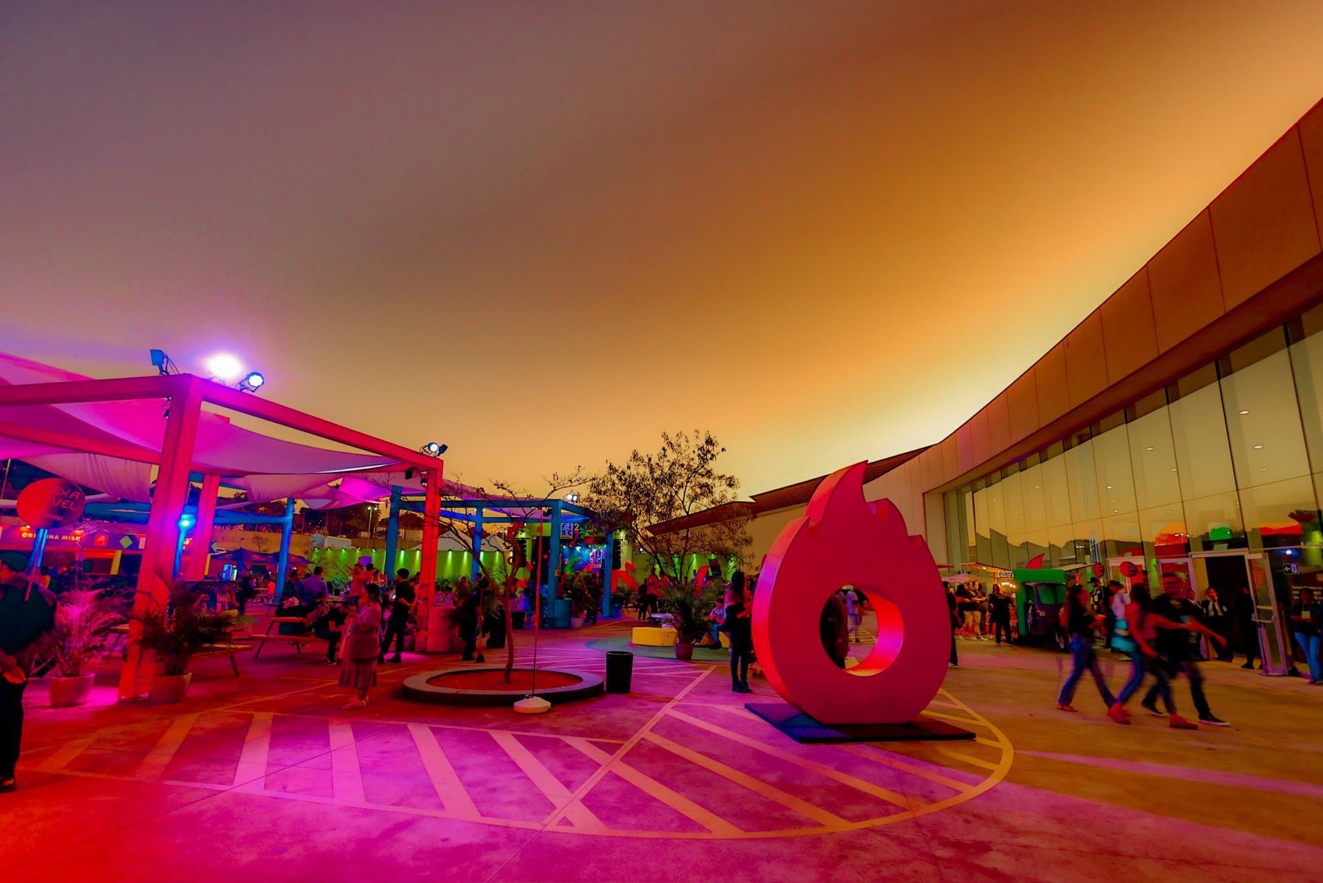 A group of people are walking around a large pink sculpture.