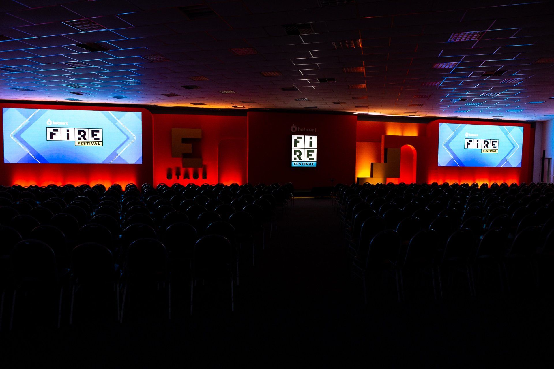A large auditorium filled with people watching a presentation