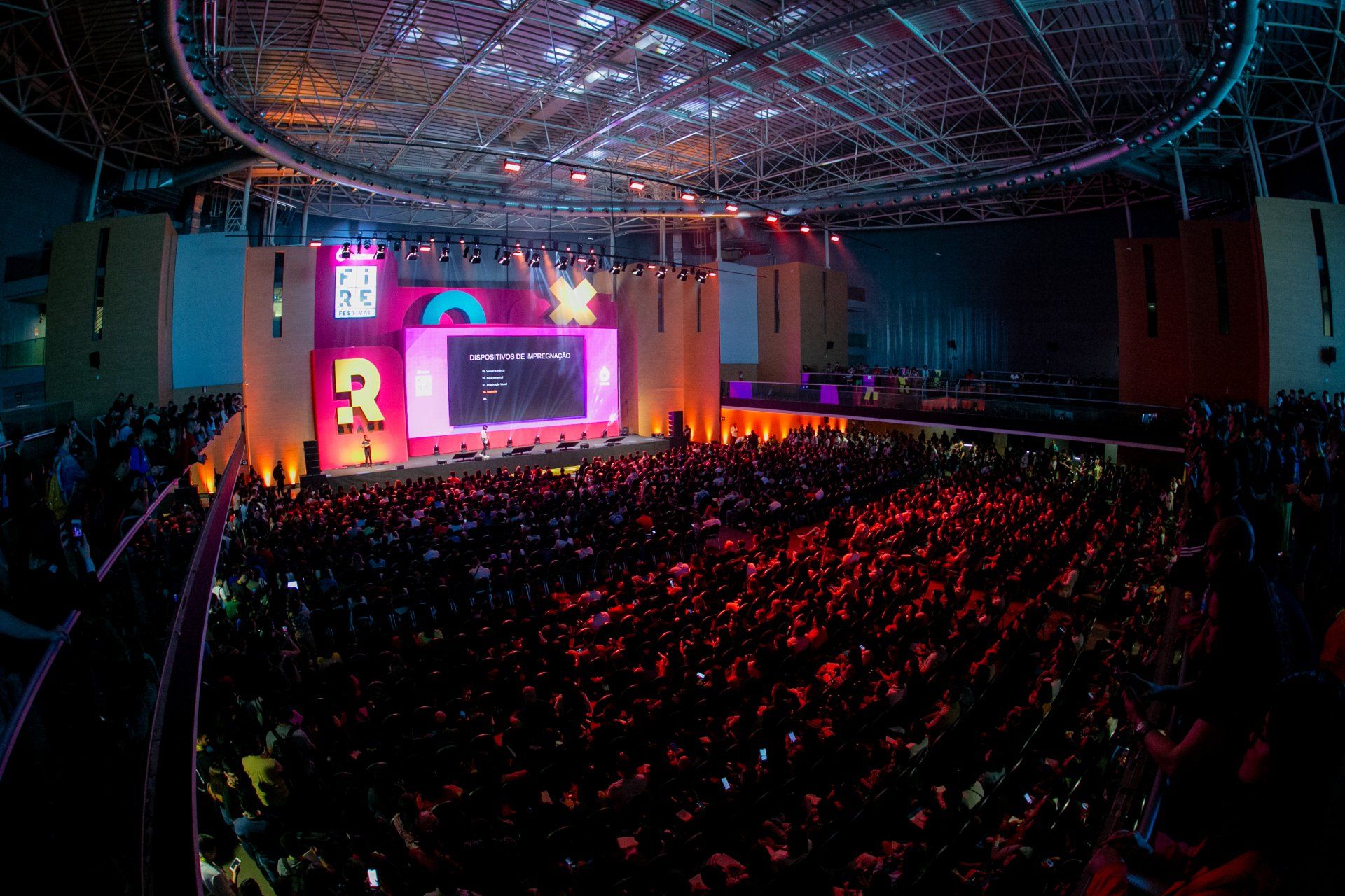 A large crowd of people are sitting in front of a stage at a concert.