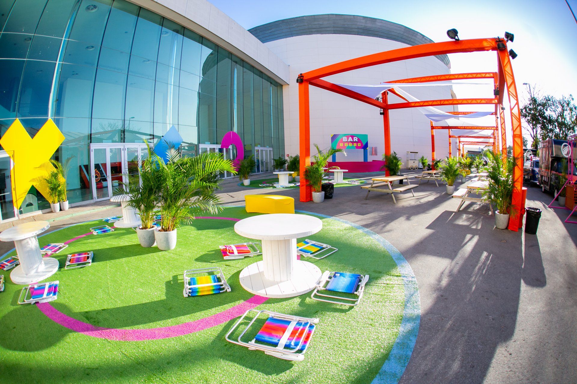 A large building with a lot of tables and chairs in front of it.