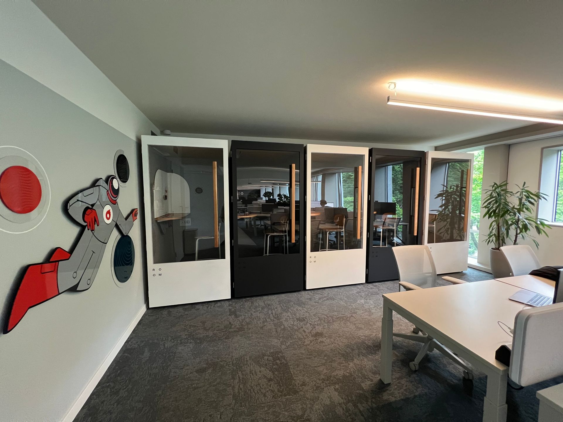 Uma sala com uma mesa, cadeiras e uma pintura na parede.
