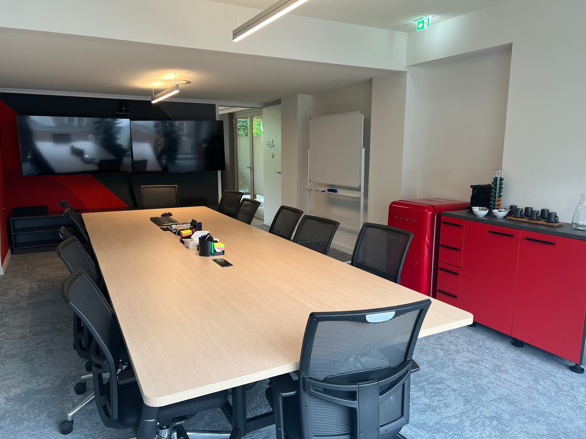 Uma sala de conferências com uma mesa longa e cadeiras.