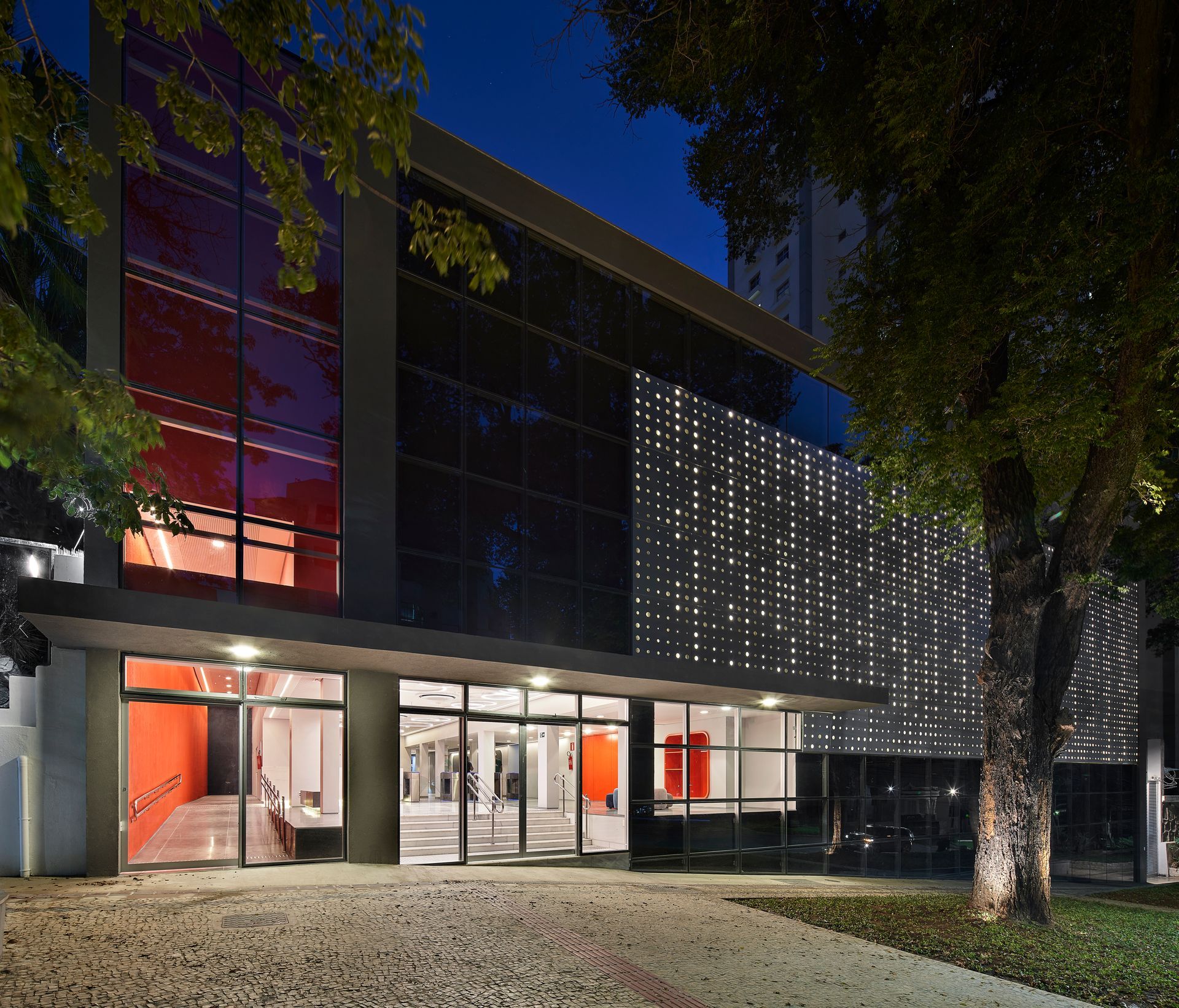 Um grande edifício com muitas janelas é iluminado à noite