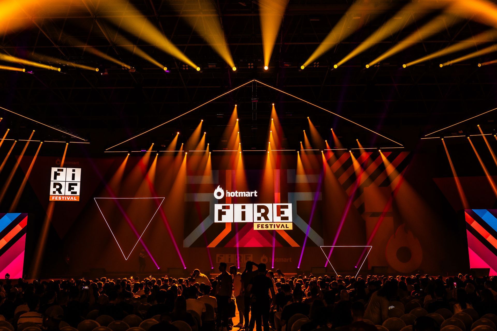 A crowd of people are gathered in front of a stage that says pure