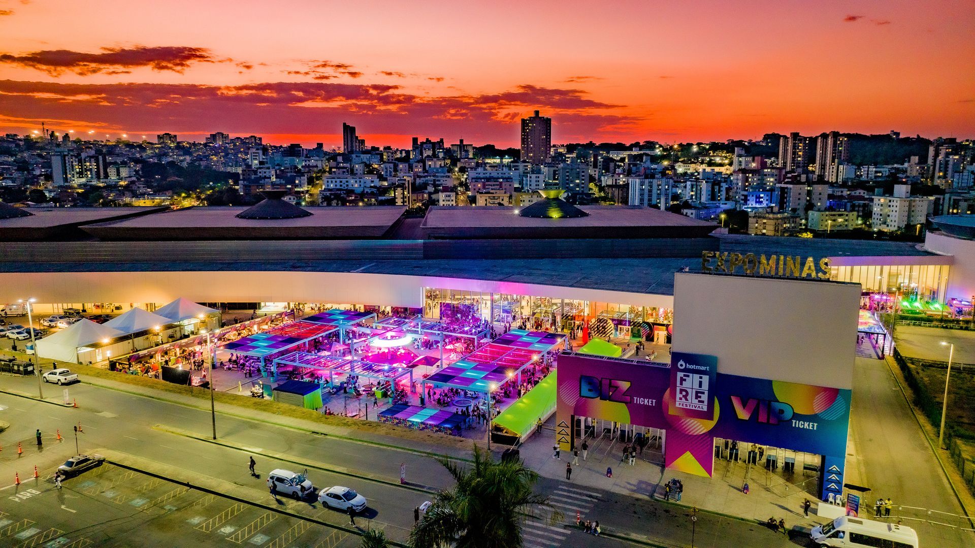 An aerial view of a carnival with a sunset in the background.