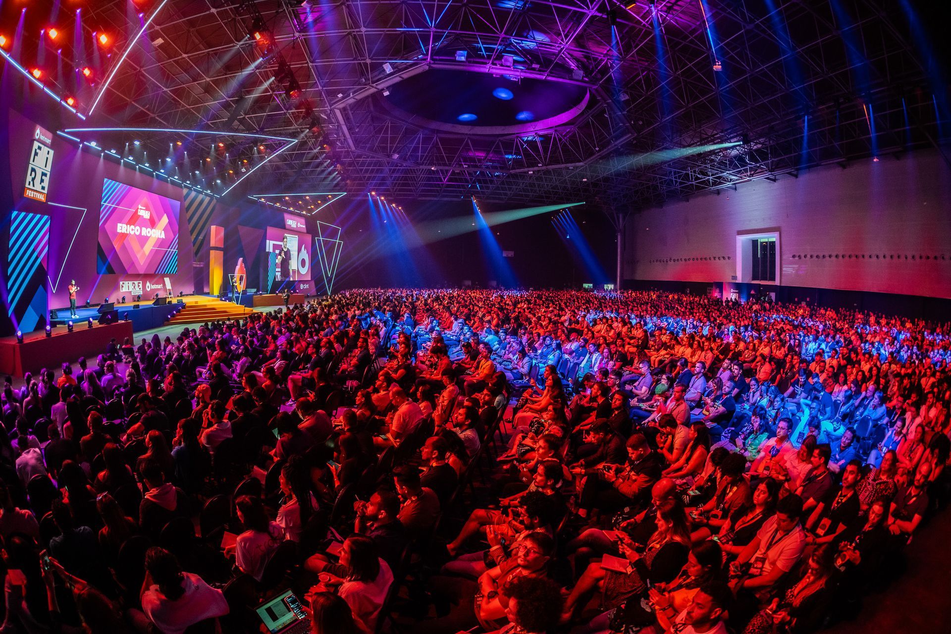 A large crowd of people are sitting in front of a stage at a concert.