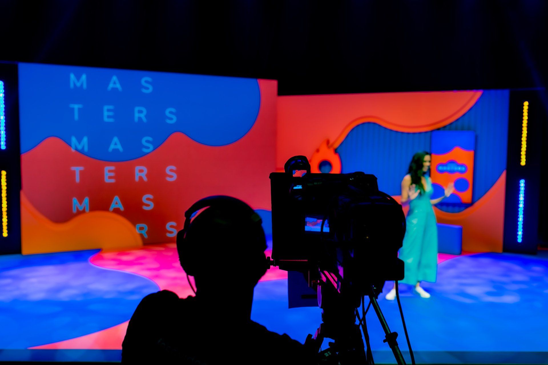 A cameraman is taking a picture of a woman on a stage.