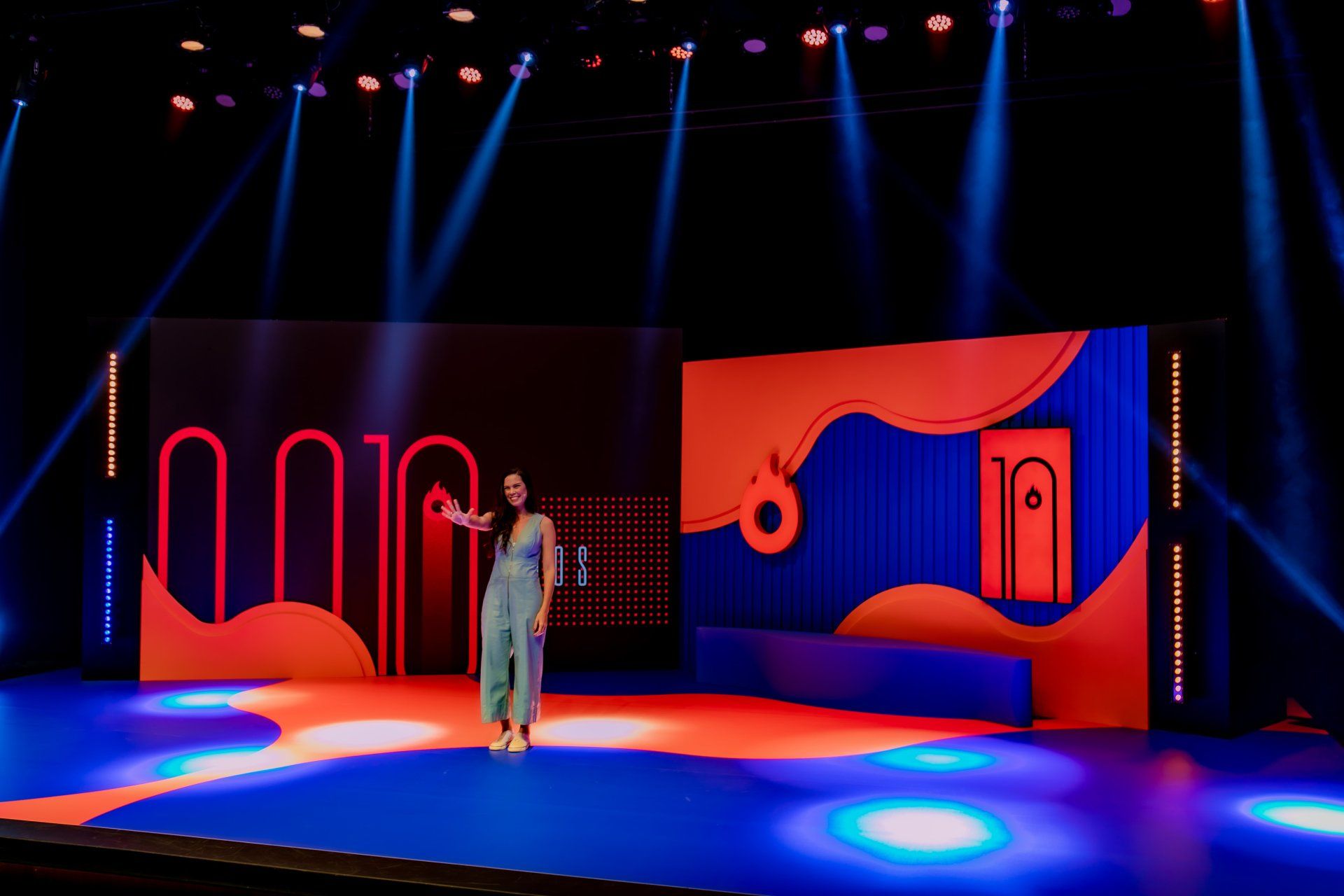 A woman is standing on a stage with a microphone in her hand.