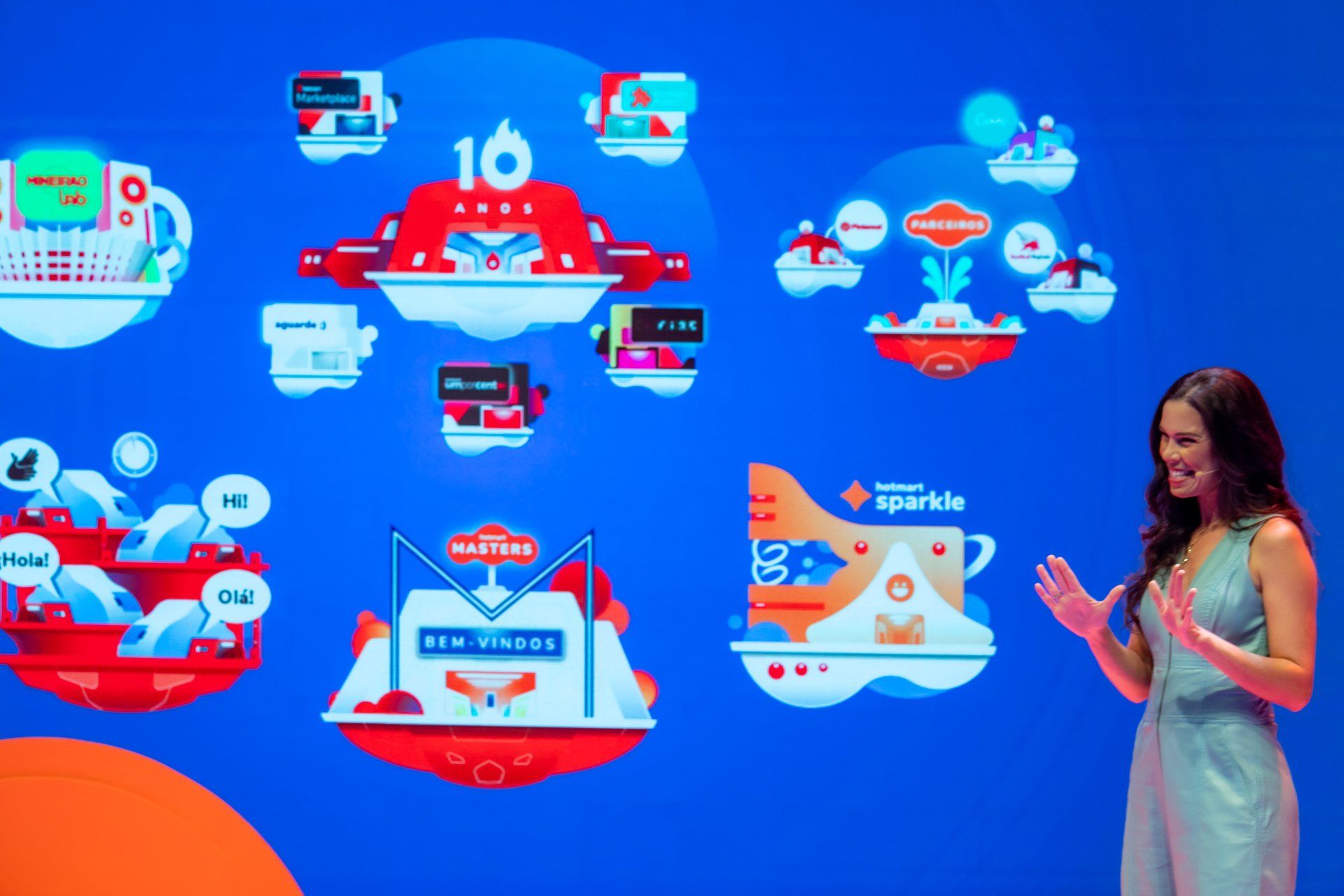 A woman is standing in front of a blue wall with a lot of icons on it