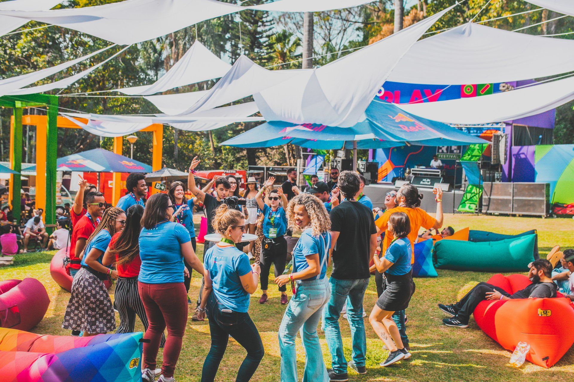 A group of people are dancing in a field at a festival.