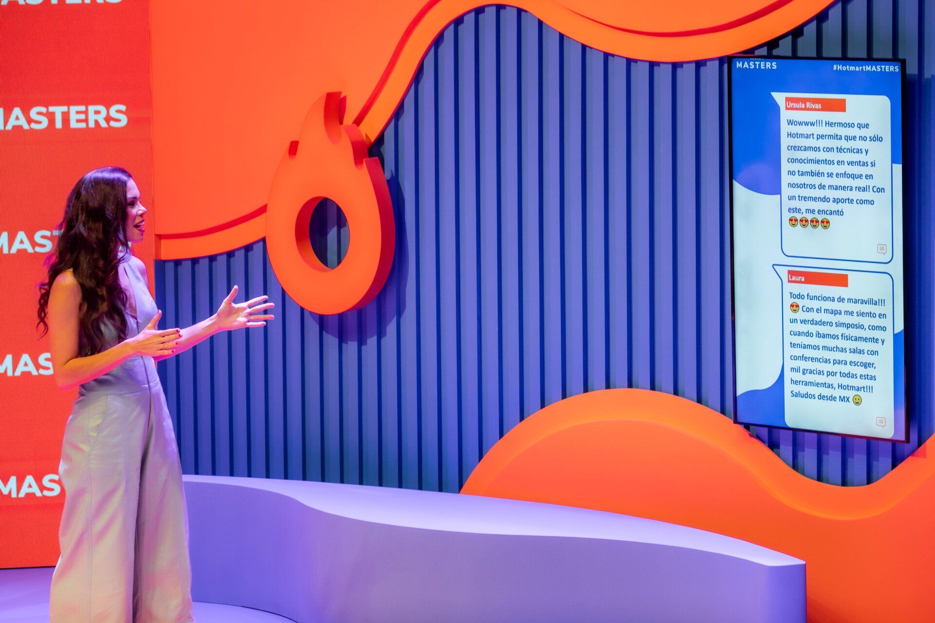 A woman is standing in front of a large screen in a room.