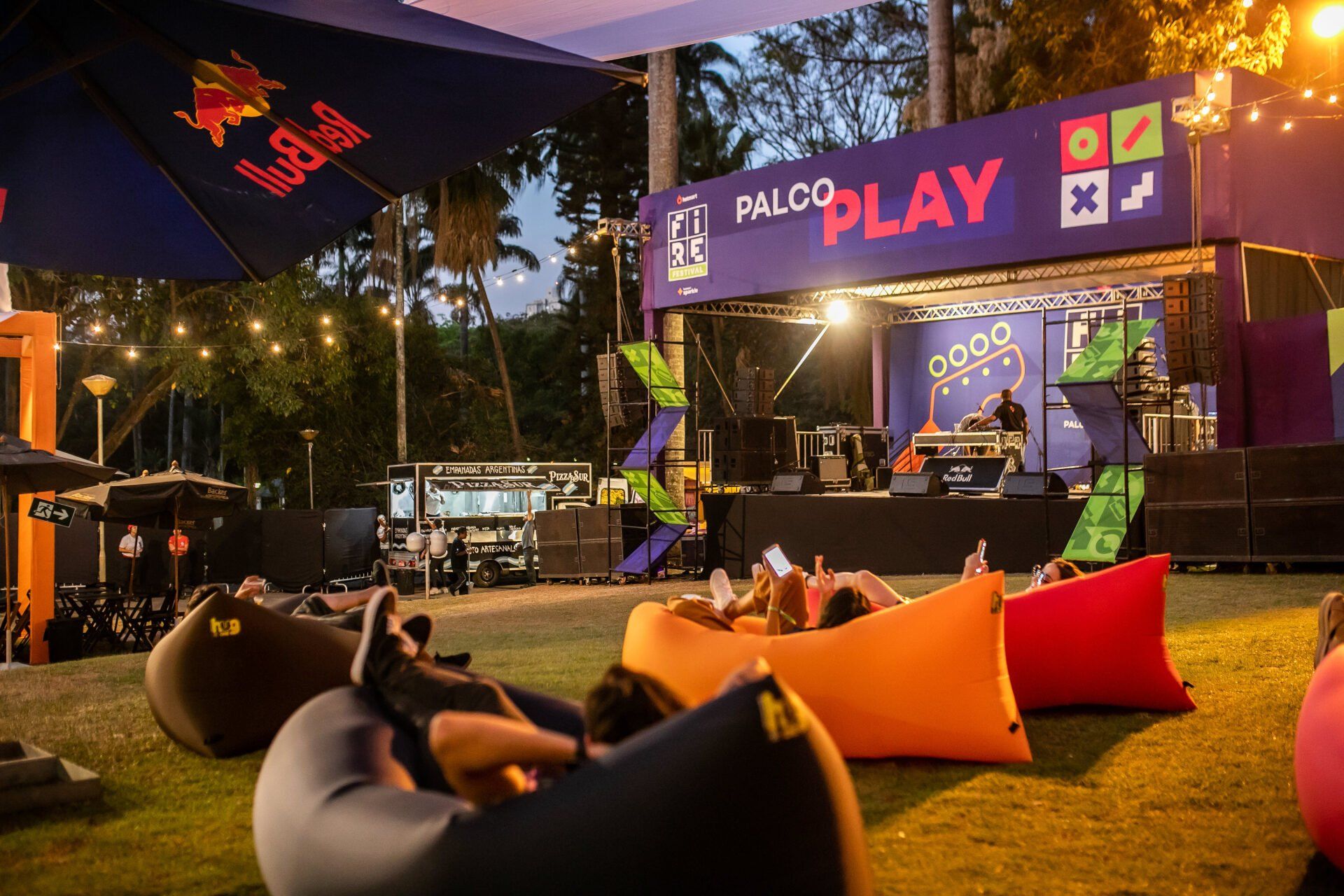 A group of people are sitting on bean bags in front of a stage.