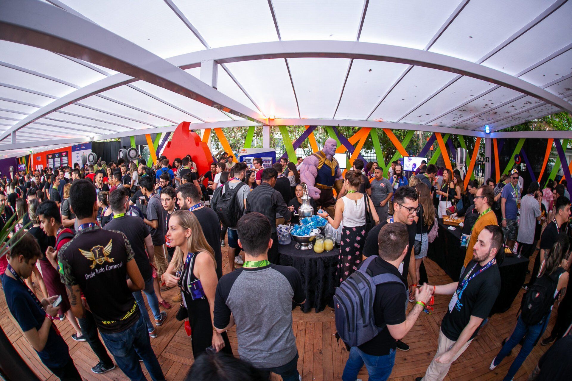 A large group of people are standing in a room under a tent.