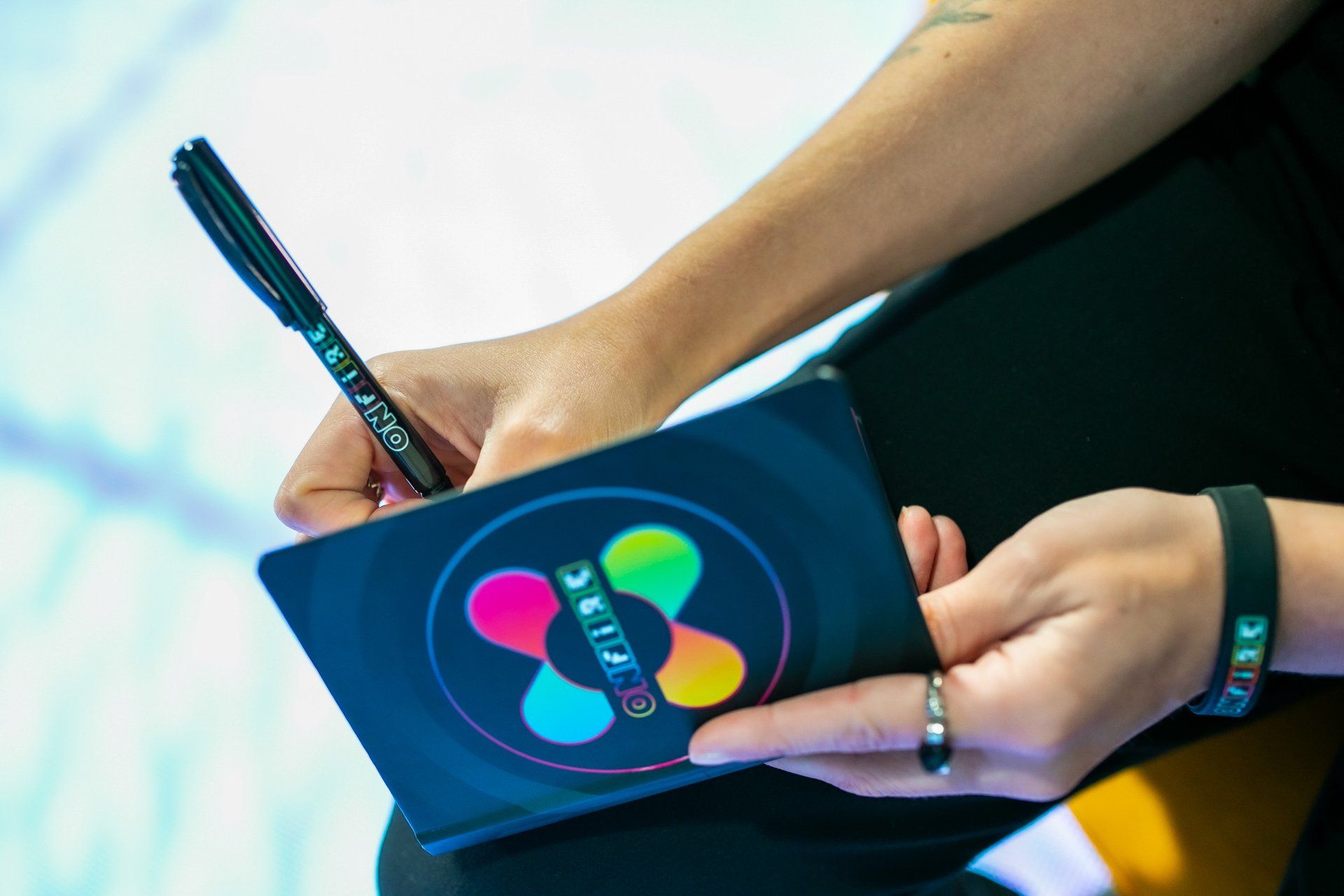 A person is writing in a notebook with a pen