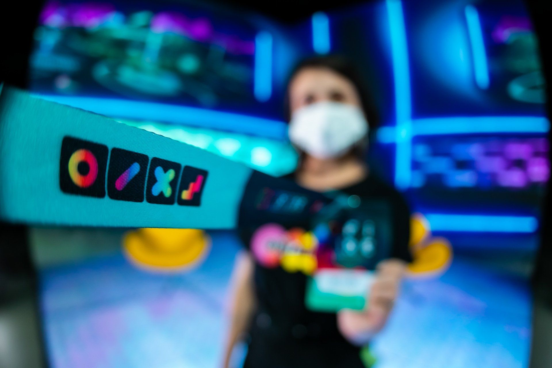 A woman wearing a mask is holding a sign that says oxo