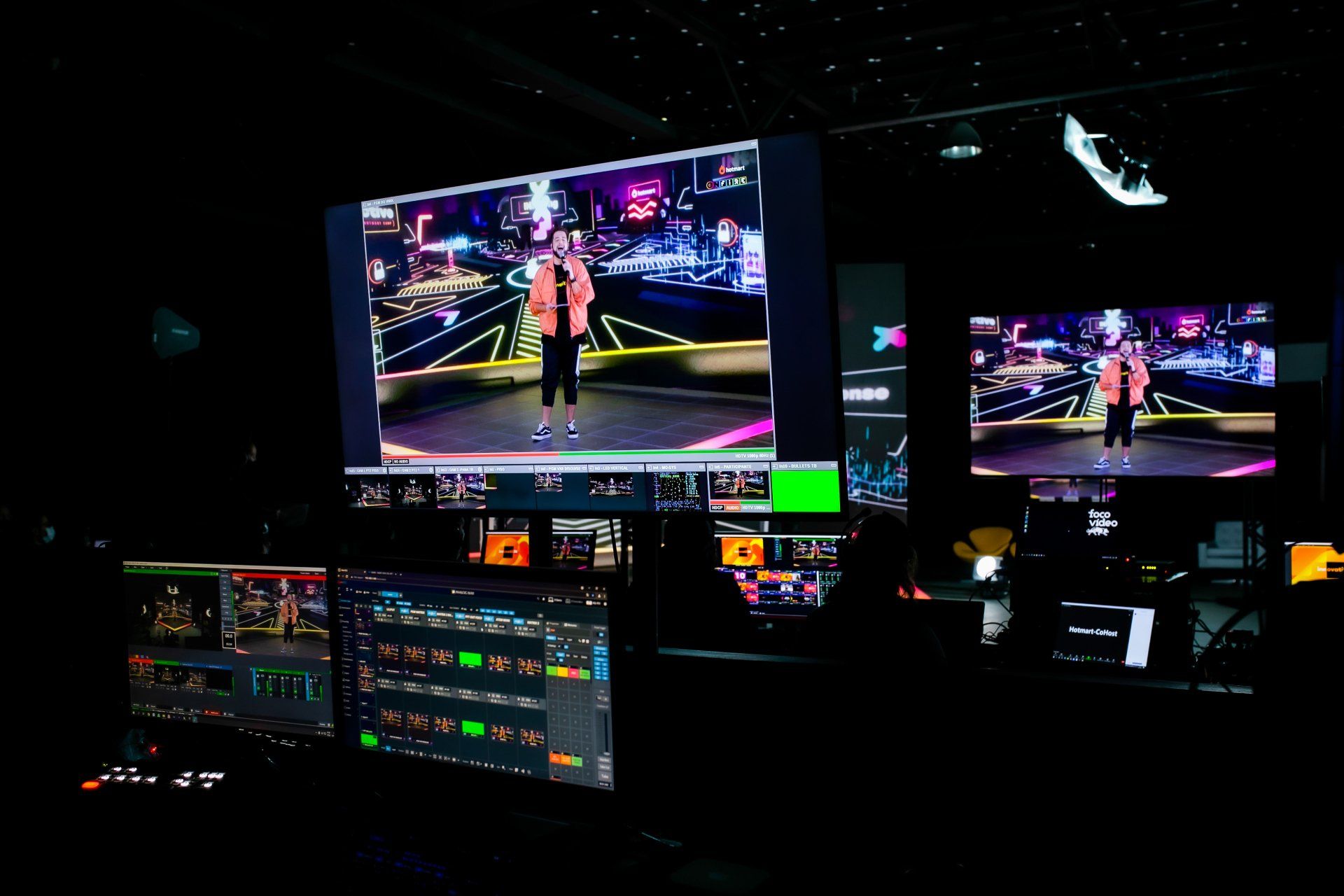 A man is standing on a stage in front of a large screen.