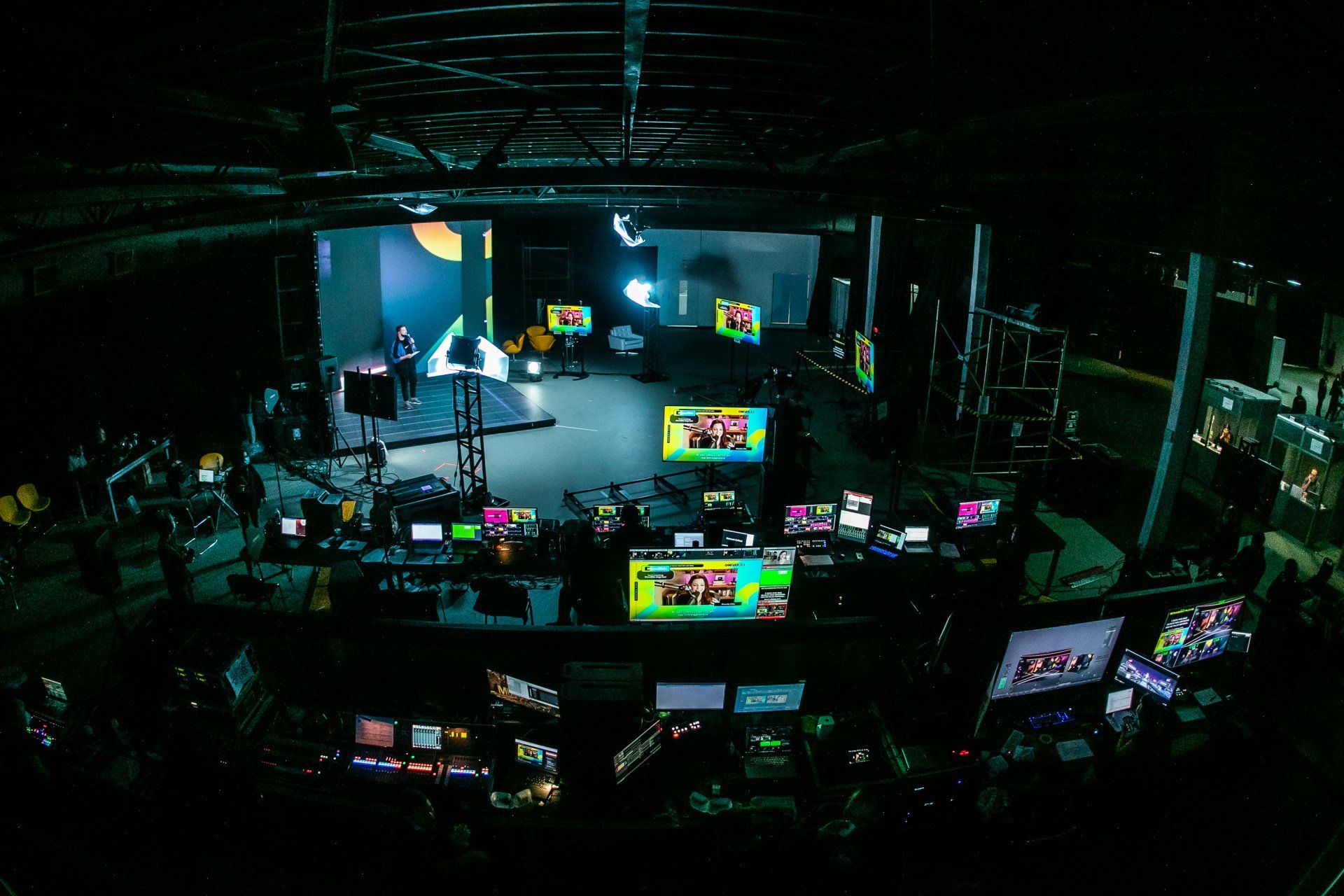 A dark room with a lot of monitors and a screen that says ' abc ' on it