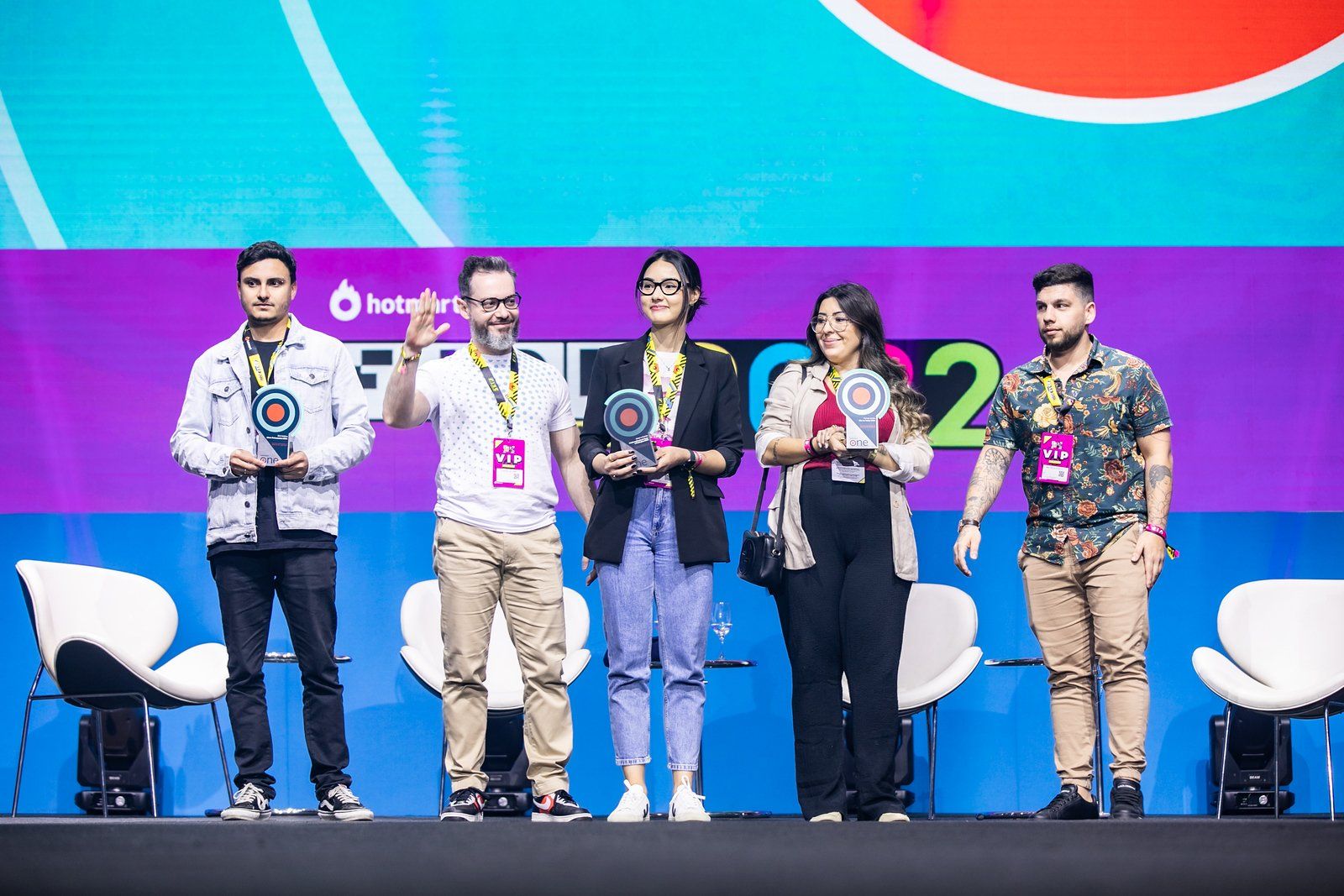 Um grupo de pessoas está em um palco segurando troféus.