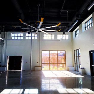 A large room with a lot of windows and a ceiling fan