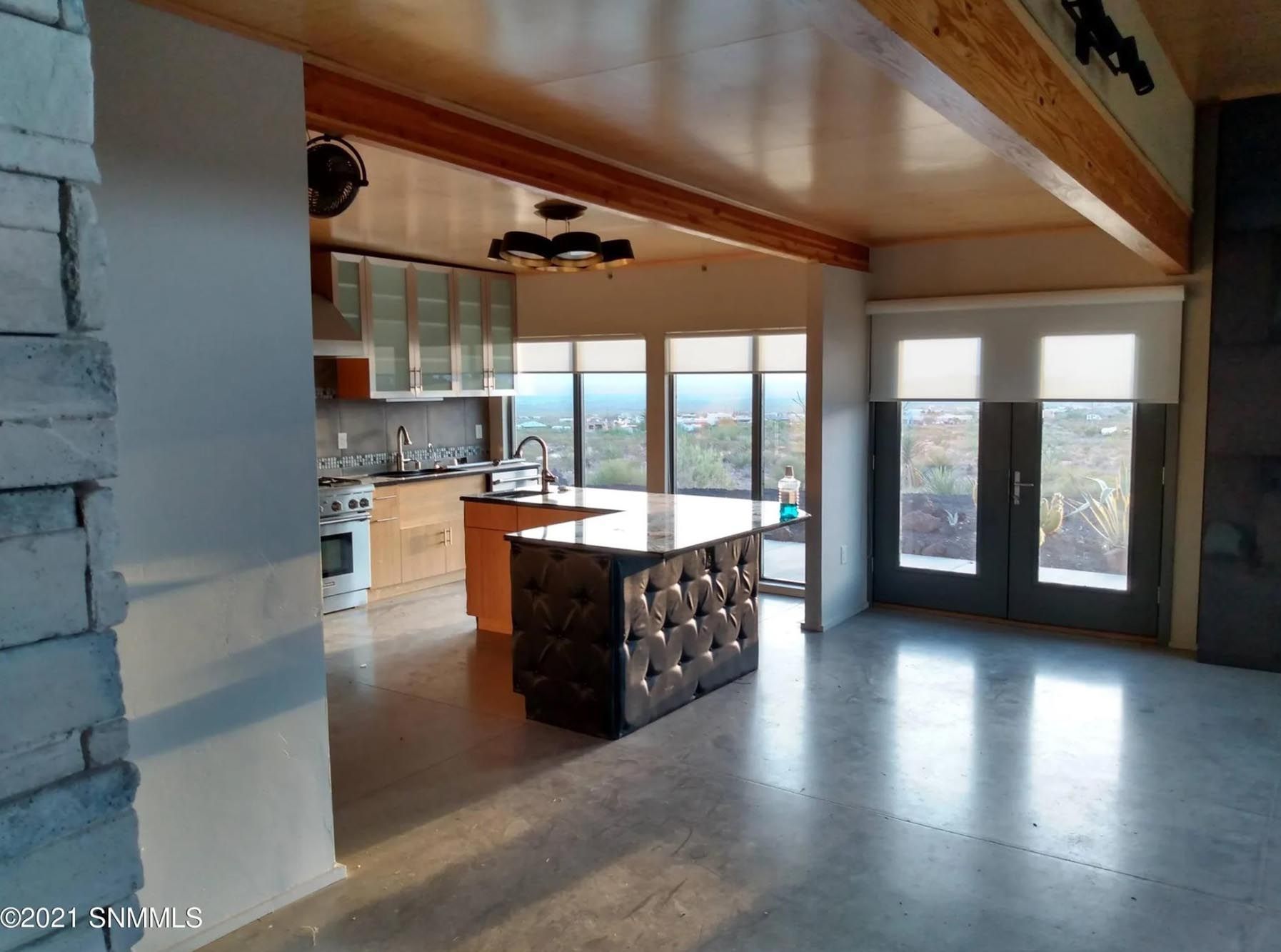 A large empty room with a kitchen and a large island in the middle.