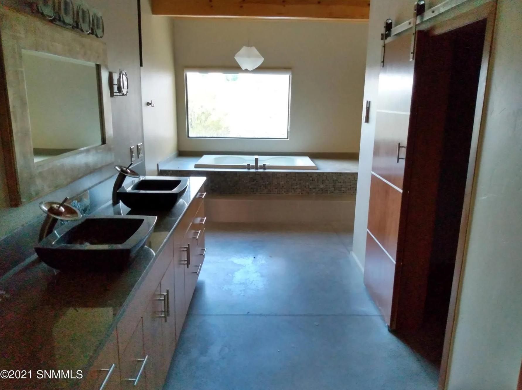 A bathroom with two sinks and a tub.