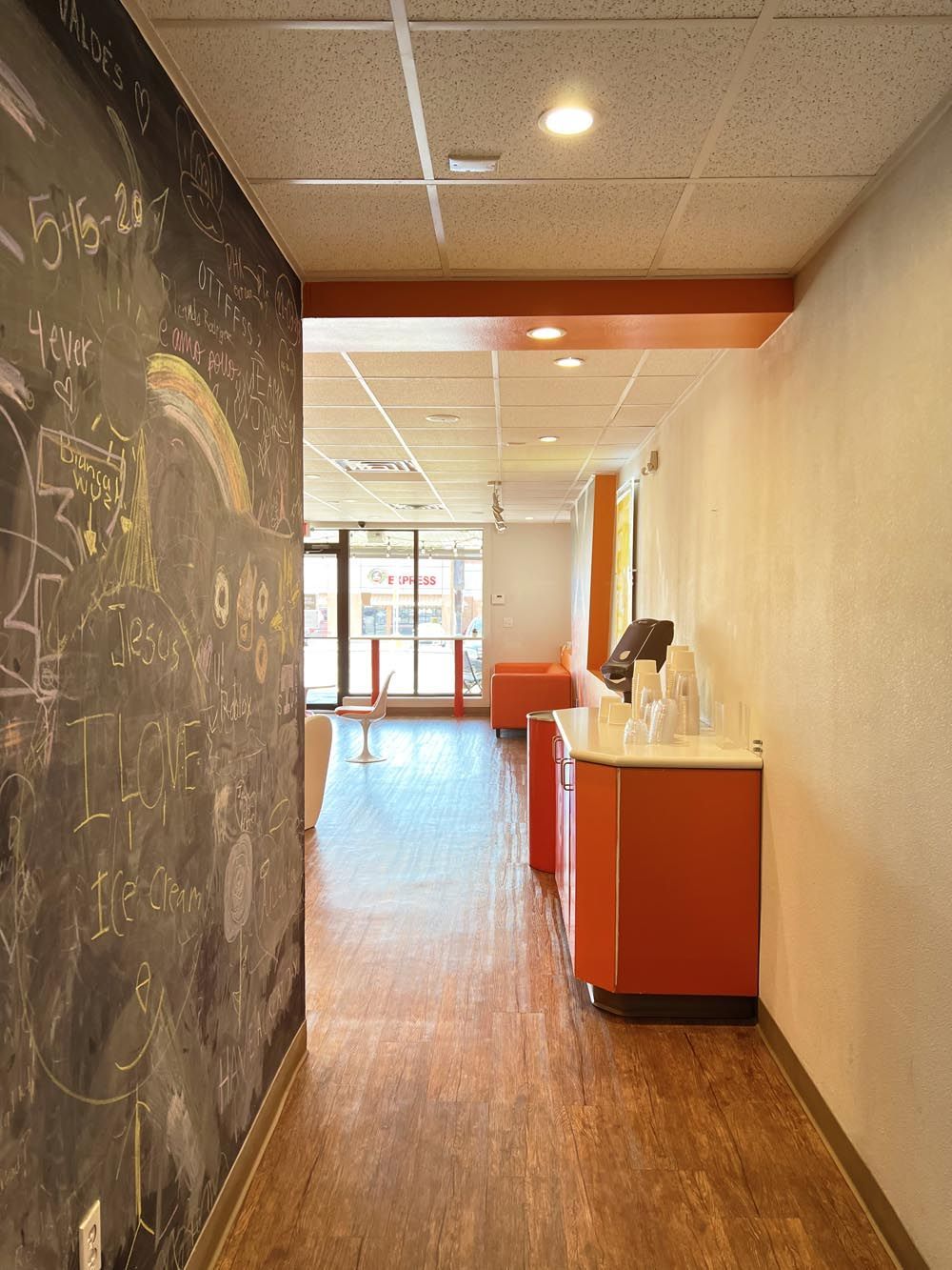 A hallway in a building with a chalkboard on the wall