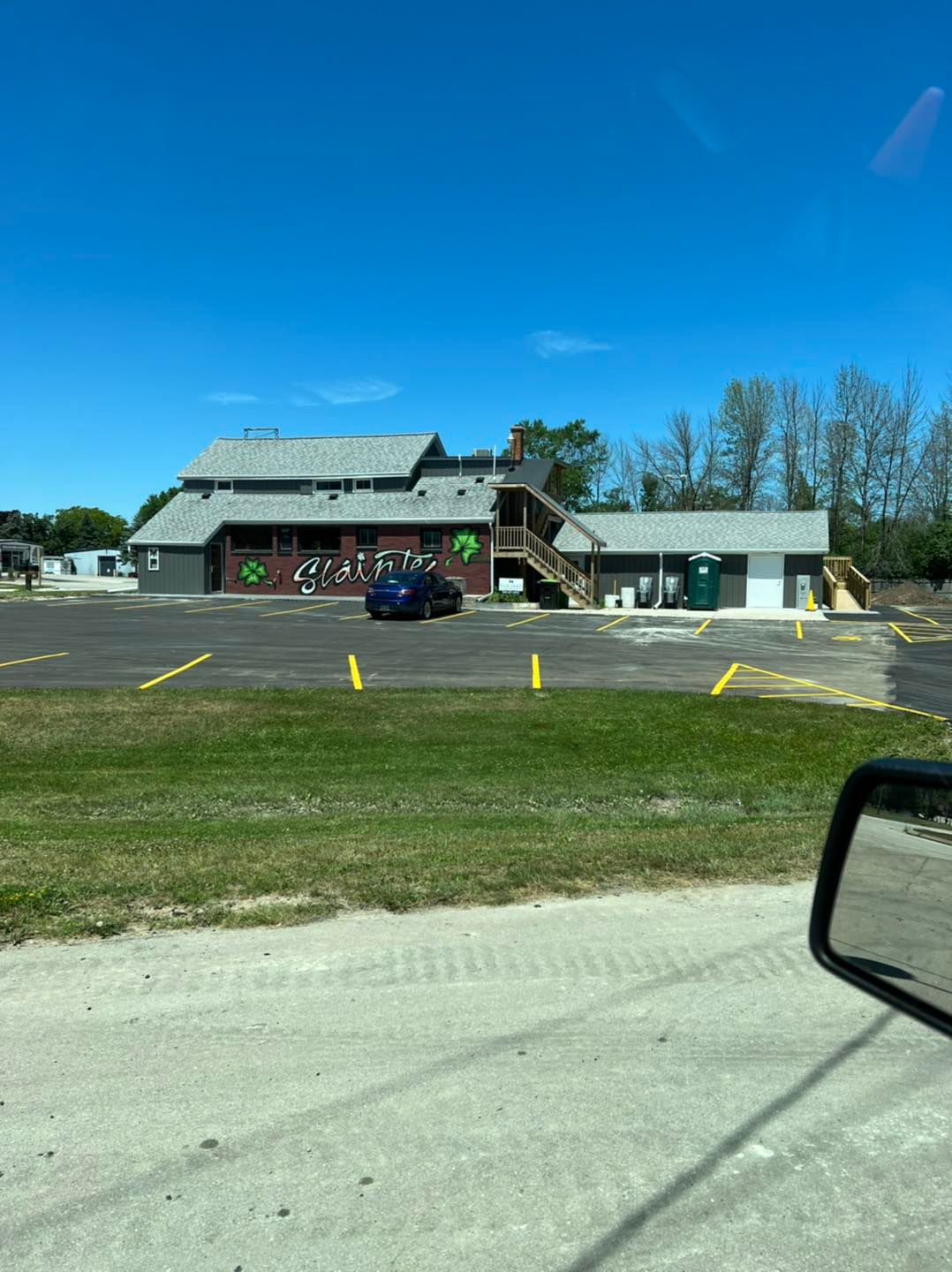 A car is parked in a parking lot in front of a building.