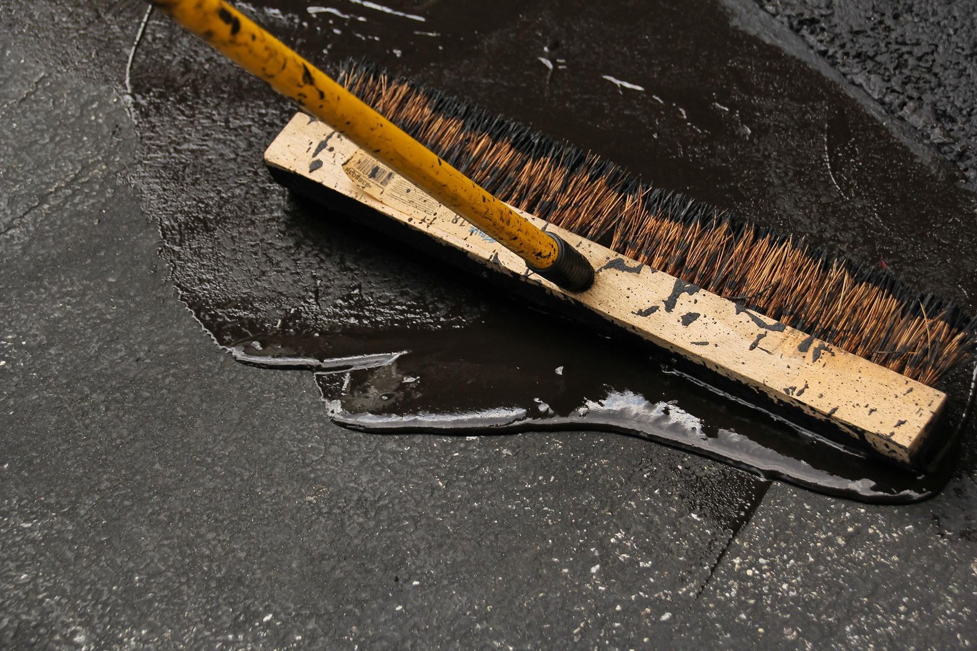 A broom is being used to clean a dirty floor