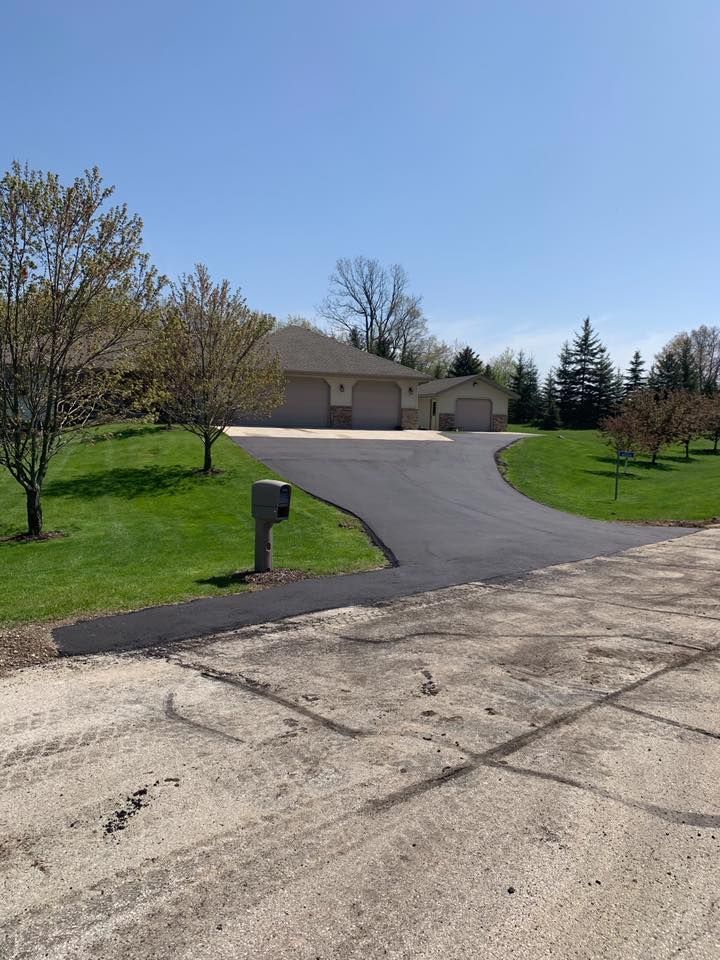 A driveway leading to a house with a mailbox on the side of it.