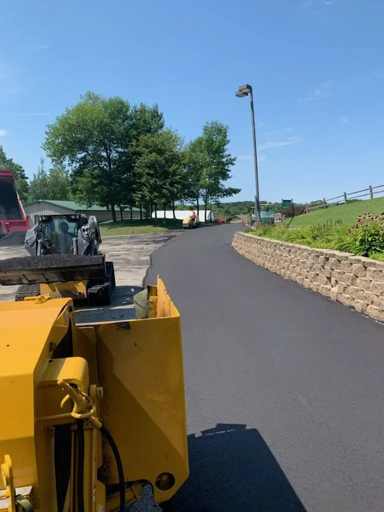 A yellow tractor is driving down a road.