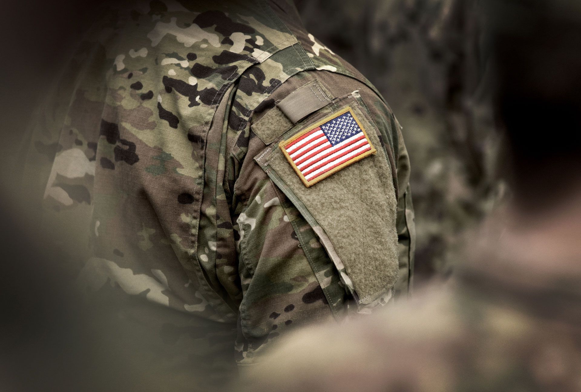 A close up of a soldier 's shoulder with an american flag on it.