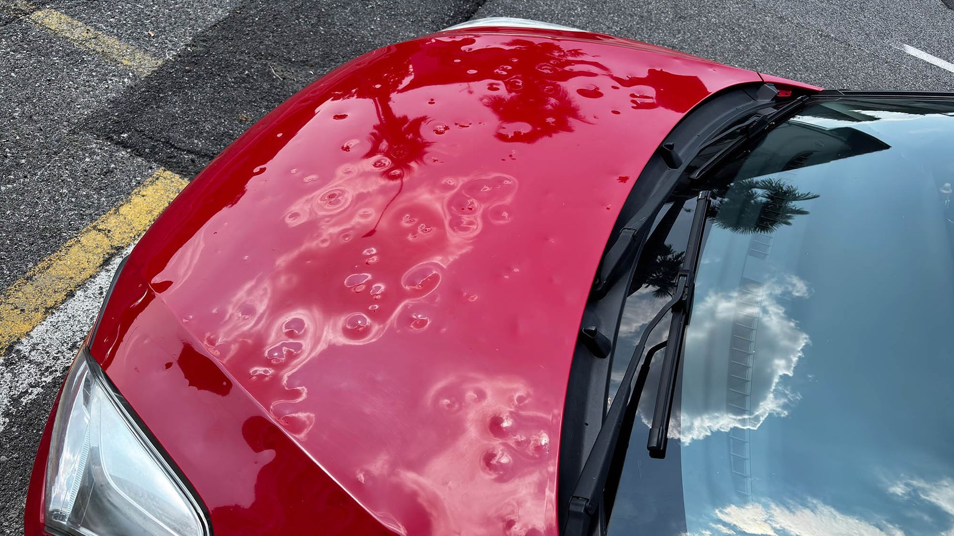 Red car hood with severe dents; expert hail damage auto repair restores your vehicle's look. Red car hood with severe dents; expert hail damage auto repair restores your vehicle's look.