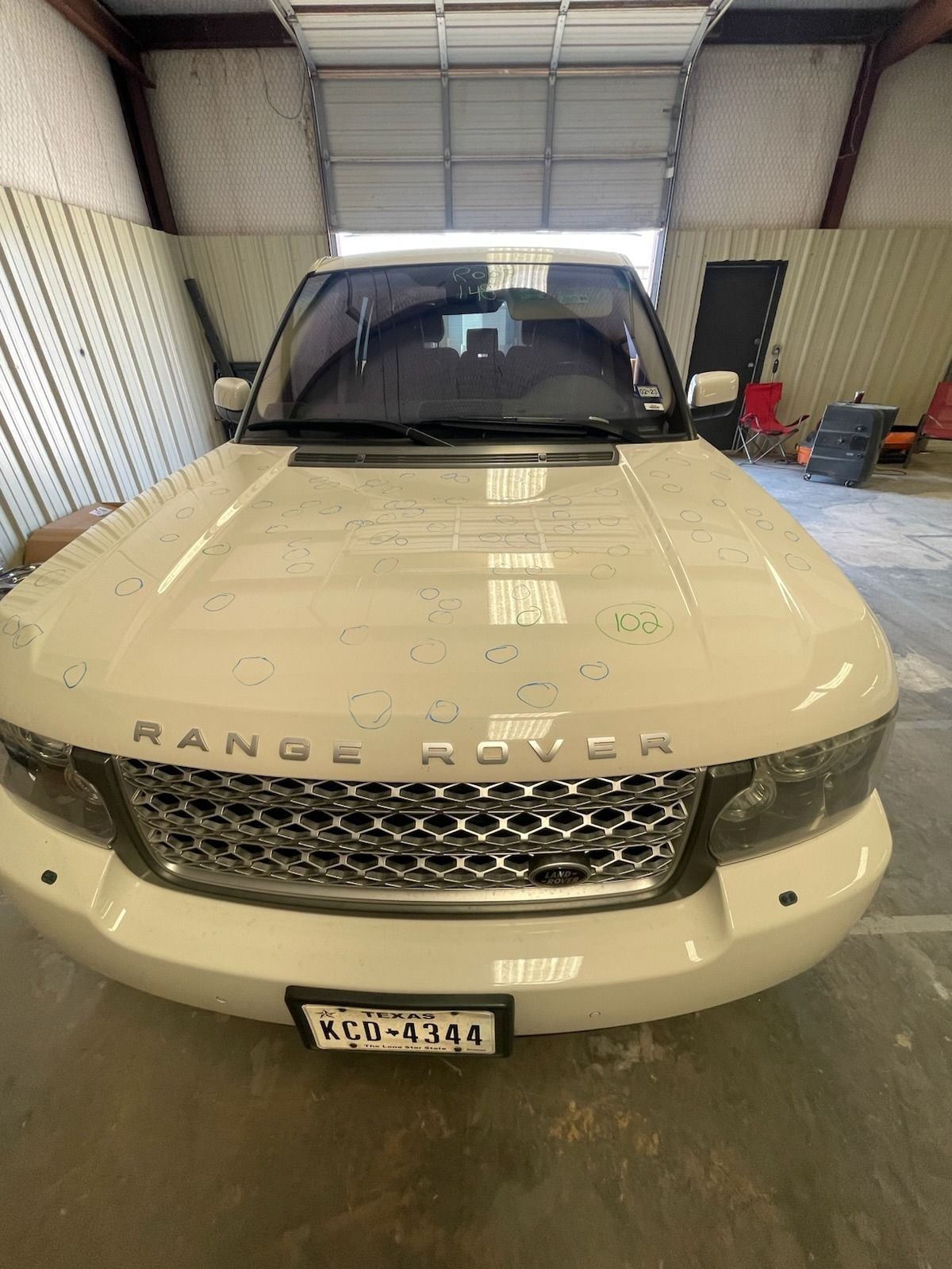 Front view of a cream Range Rover parked inside a garage