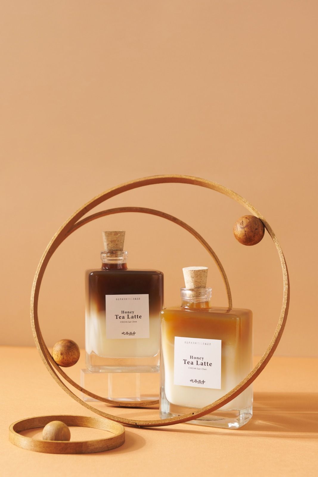 Two perfume bottles with wooden rings on a warm beige background