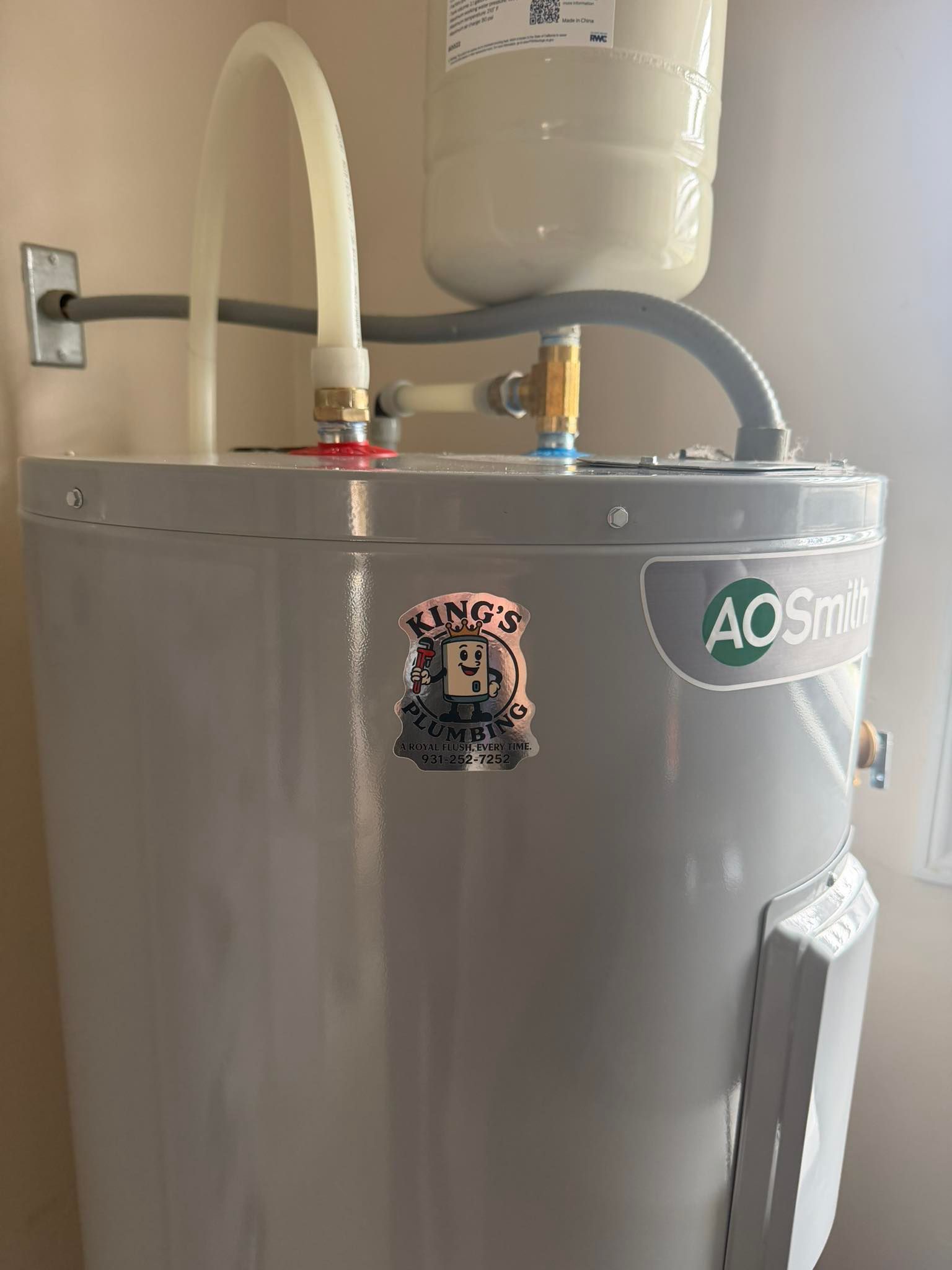 A gray A.O. Smith water heater with a small expansion tank attached to the top piping.