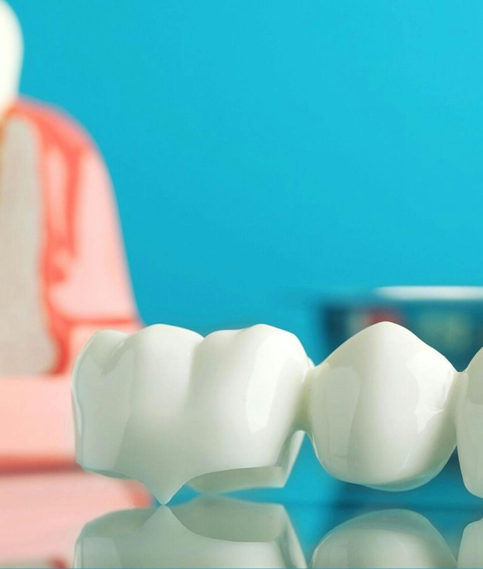 Dental bridge model with a blue background and blurry dental mold.