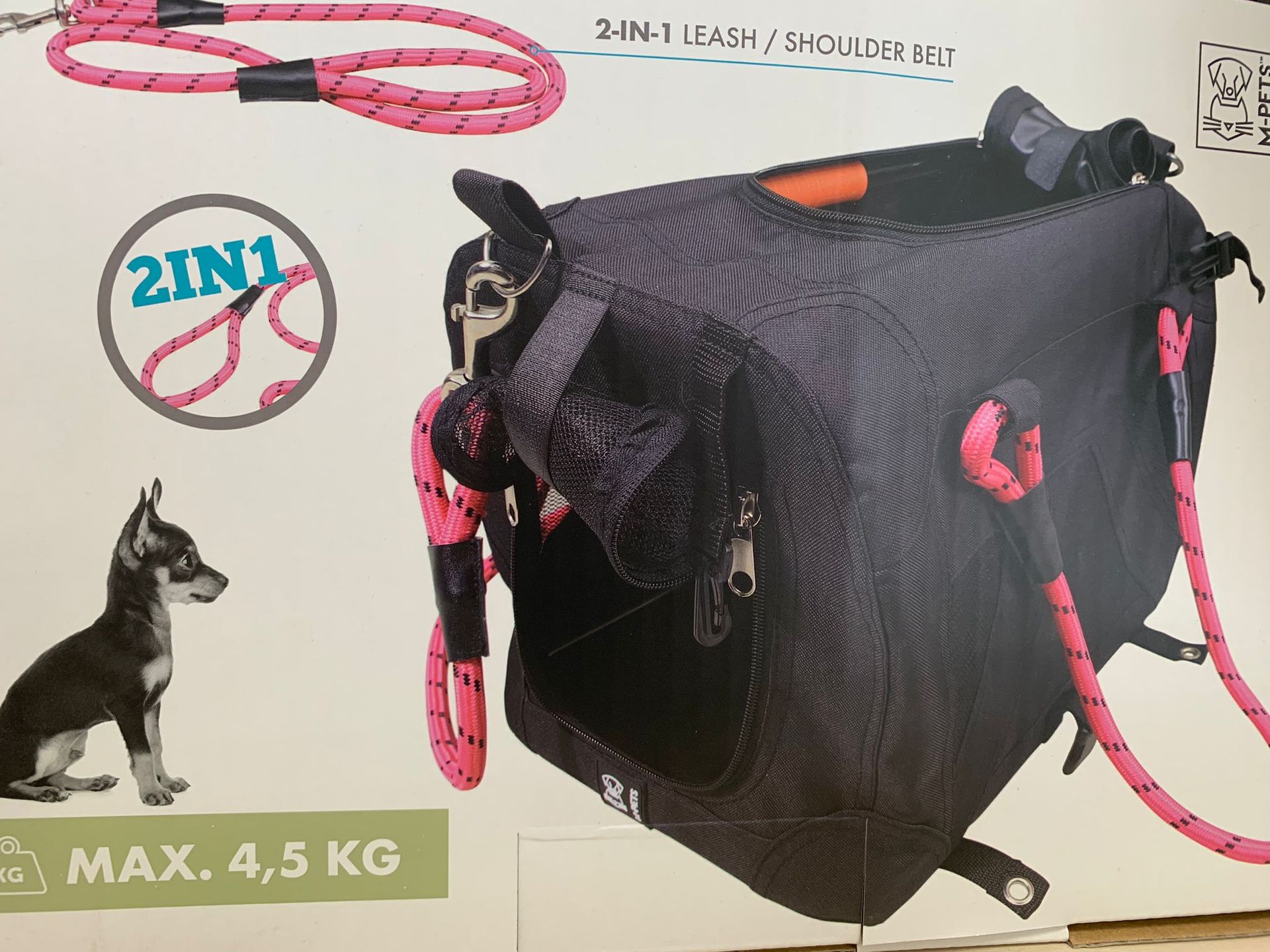 Un cagnolino è seduto accanto a una borsa con la scritta 2 in 1 max 4,5 kg