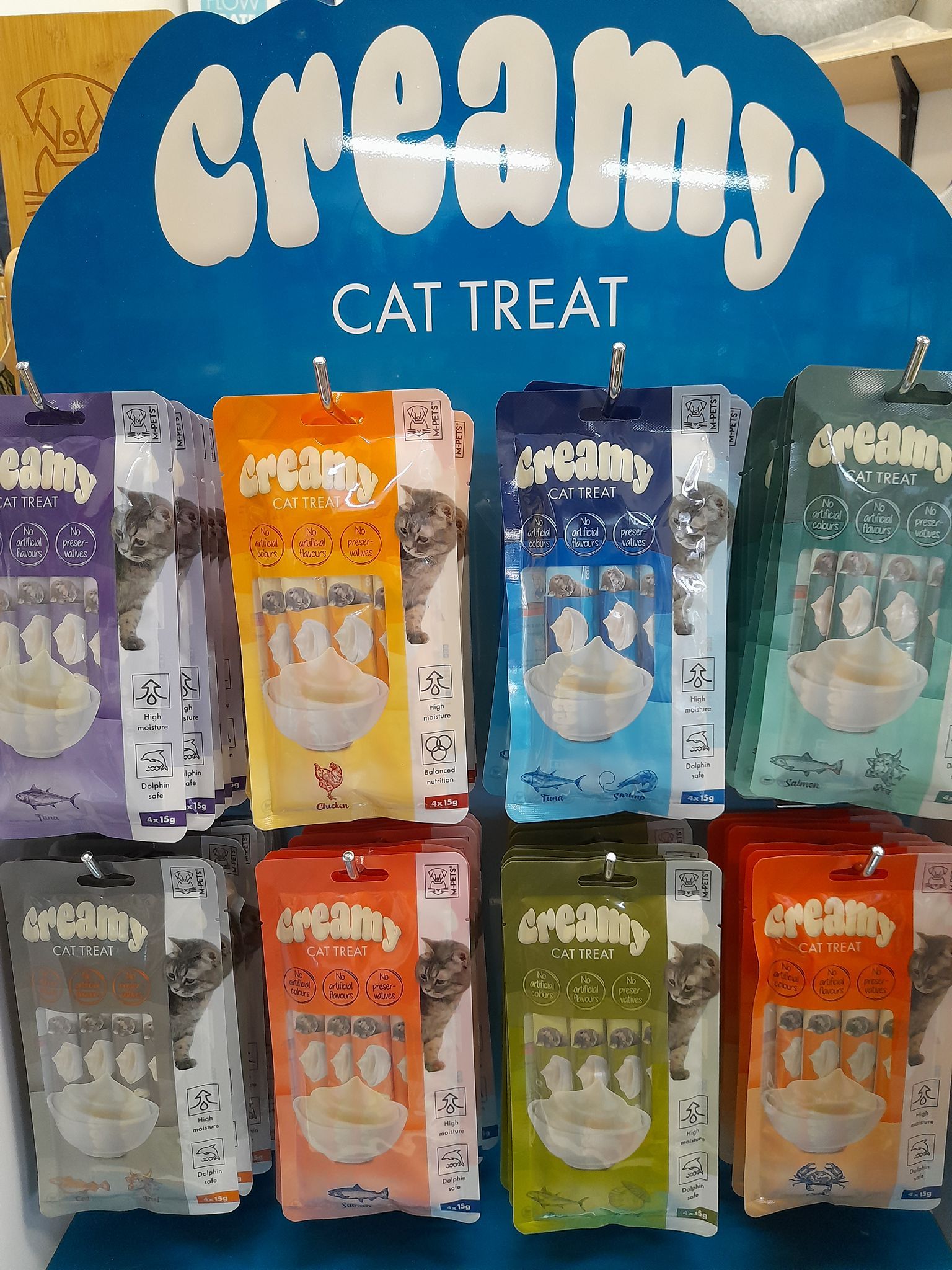 Un'esposizione di dolcetti cremosi per gatti in un negozio
