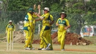 Cricket players in yellow uniforms celebrating on the field
