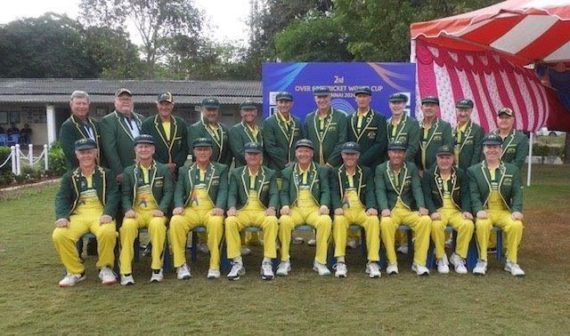 An Australian cricket team posing in green and yellow uniforms with medals