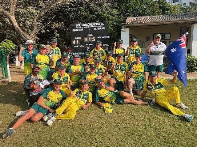 An Australian cricket team poses after a match, wearing yellow and green uniforms