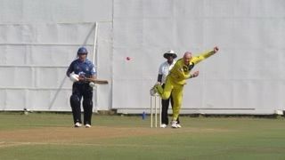 Cricketer in yellow bowls on cricket field